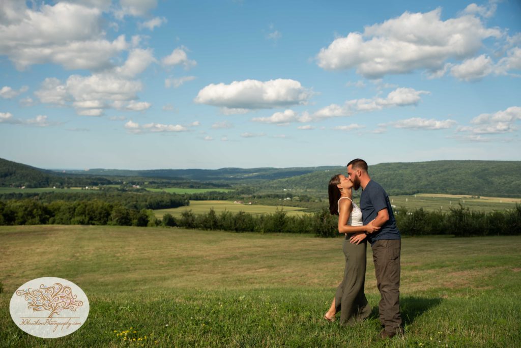 Bride and groom to be kiss overlooking the hills of Lafayette NY on Route 20 at Beak and SKiff's Distillery