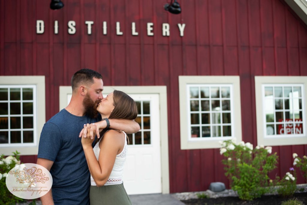 Groom kisses bride with his arm wrapped around her tightly at Beak and Skiff's Distillery