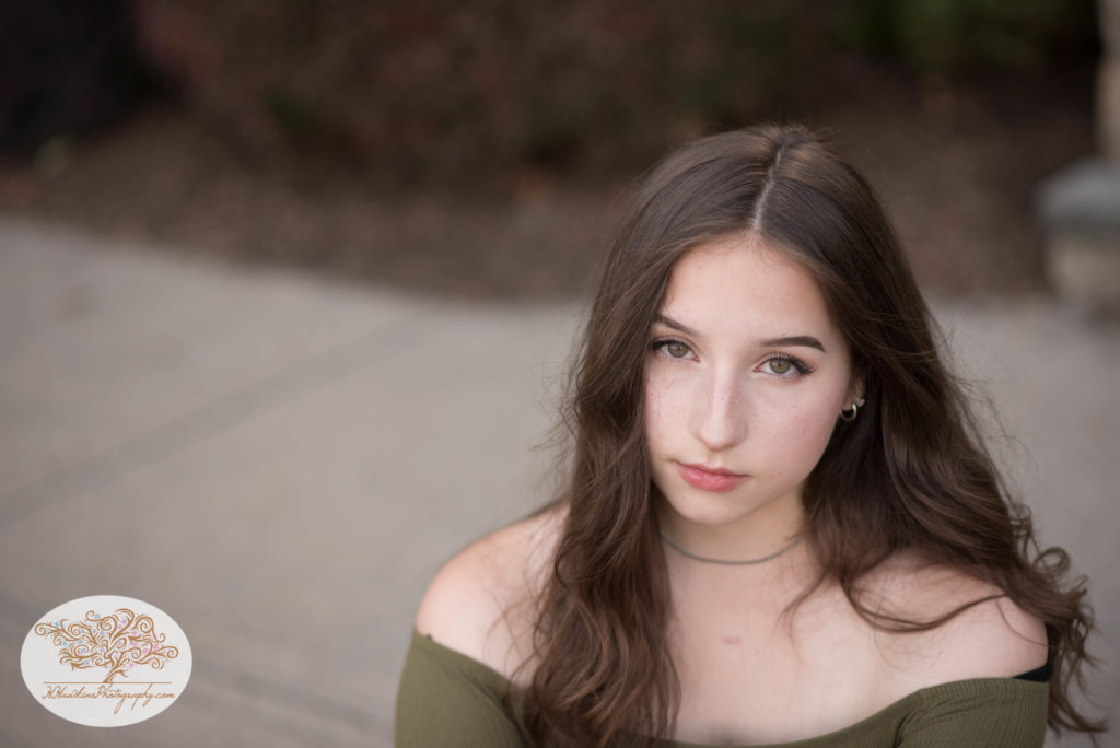 Senior picture of girl with green eyes posing with serious face 