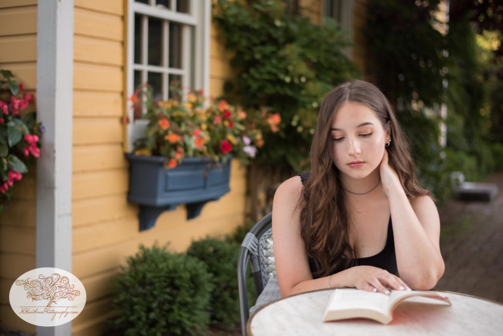 Syracuse senior picture of girl reading a book at cafe