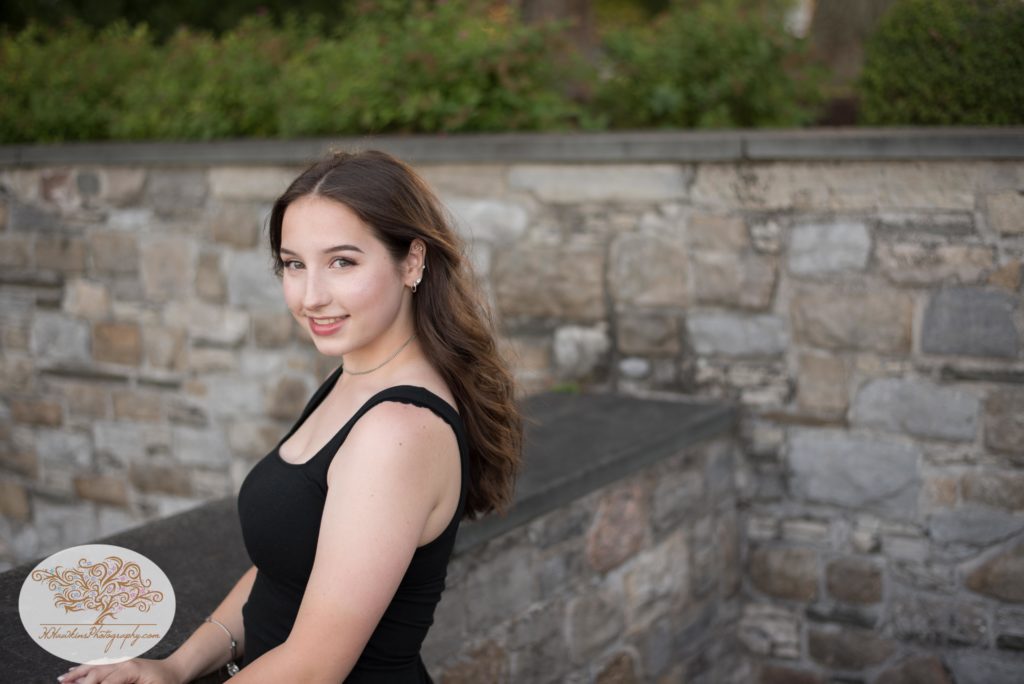 Syracuse senior photographer takes picture of girl in front of stone wall