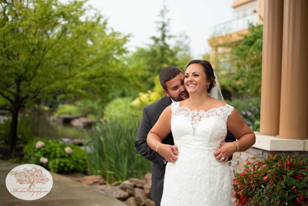Groom sneaks up behind bride and tickles her for a picture