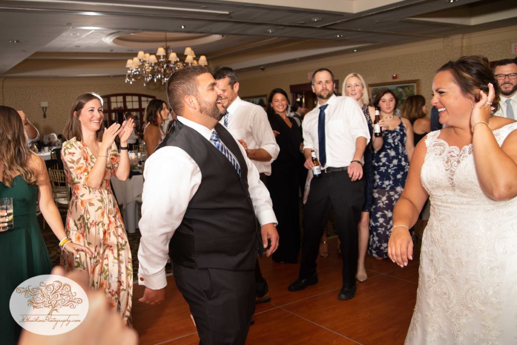 Bride laughs as groom dances during wedding reception at Shenendoah Clubhouse