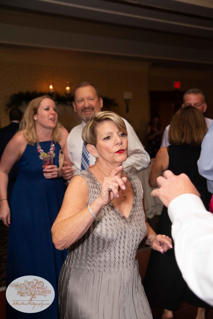 mother of the groom dances during wedding reception captured by Syracuse photographer