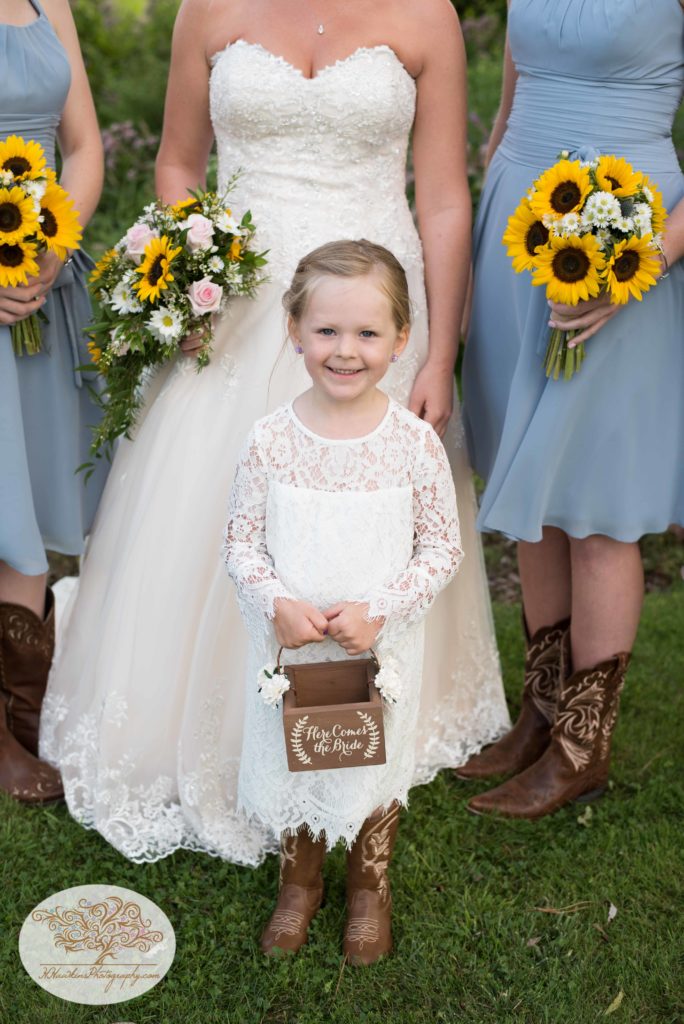 Flower girl holds box that says Here Comes the Bride for Upstate NY barn wedding