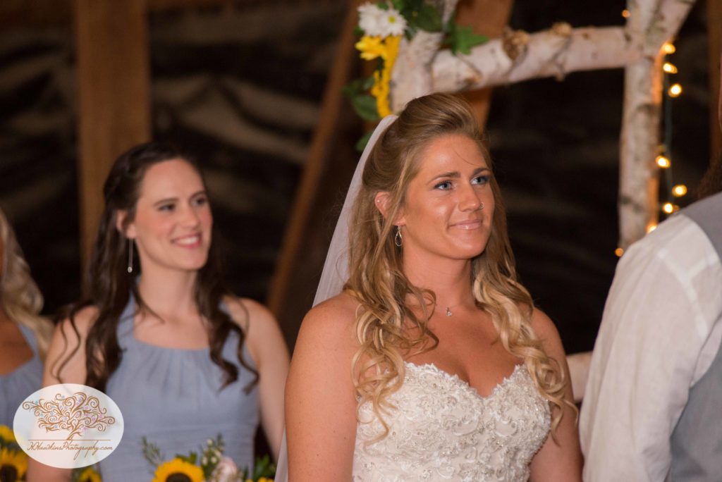 Bride and her Maid of Honor with White Birch arbor during the upstate NY barn wedding ceremony