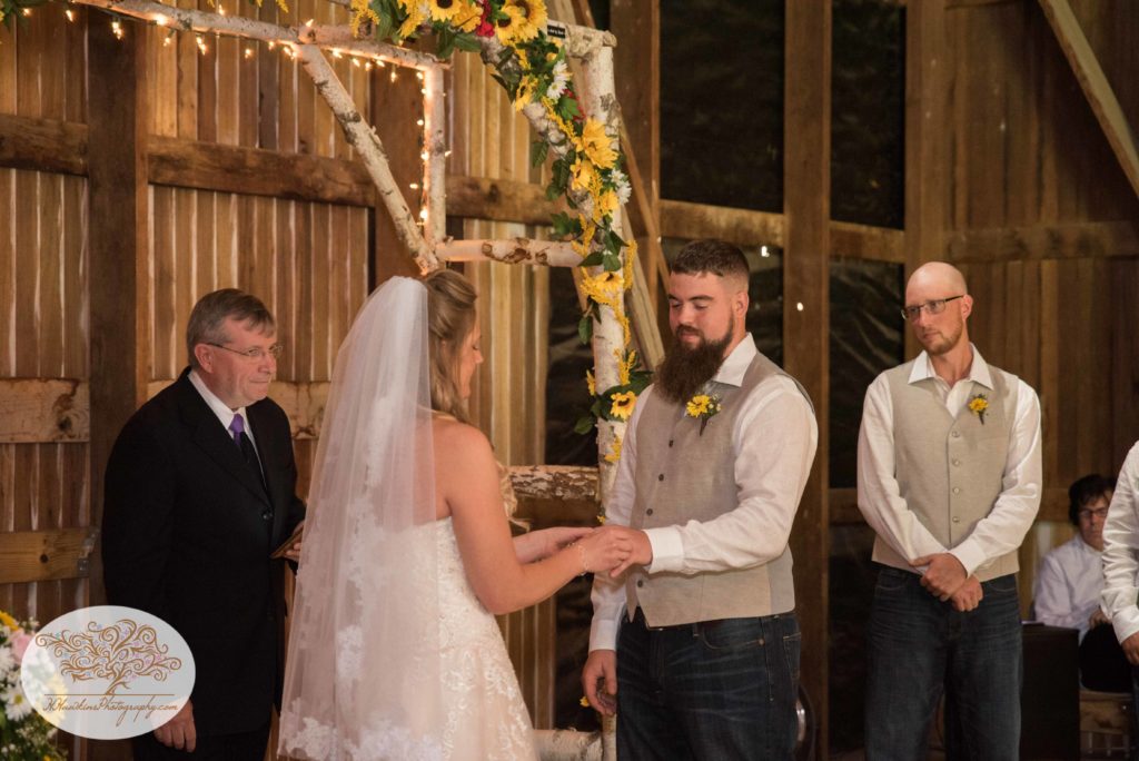 Bride and groom exchange rings during Upstate NY barn wedding