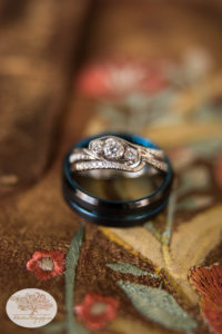 Engagement ring and wedding bands on cowgirl boots for barn wedding