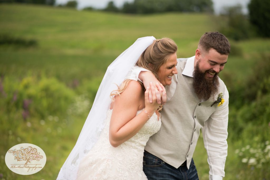 Bride and groom do a candid pose that looks natural during Upstate NY barn wedding by Syracuse photographer