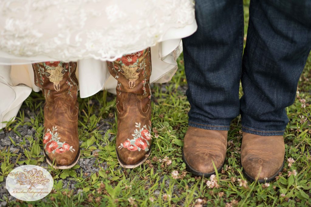 Bride and groom wear cowboy and cowgirl boots at their farm during Upstate NY barn wedding