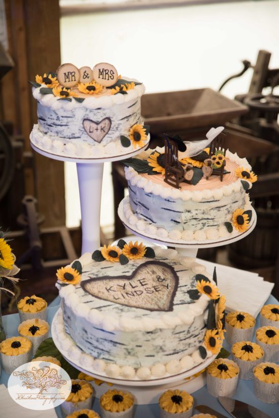 White birch Wedding cake with sunflowers, rocking chairs and cowboy hats for Upstate NY barn reception