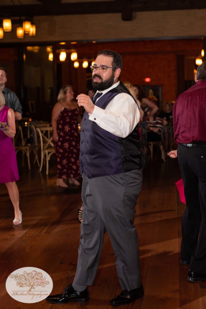 Groomsmen dances to music during wedding reception