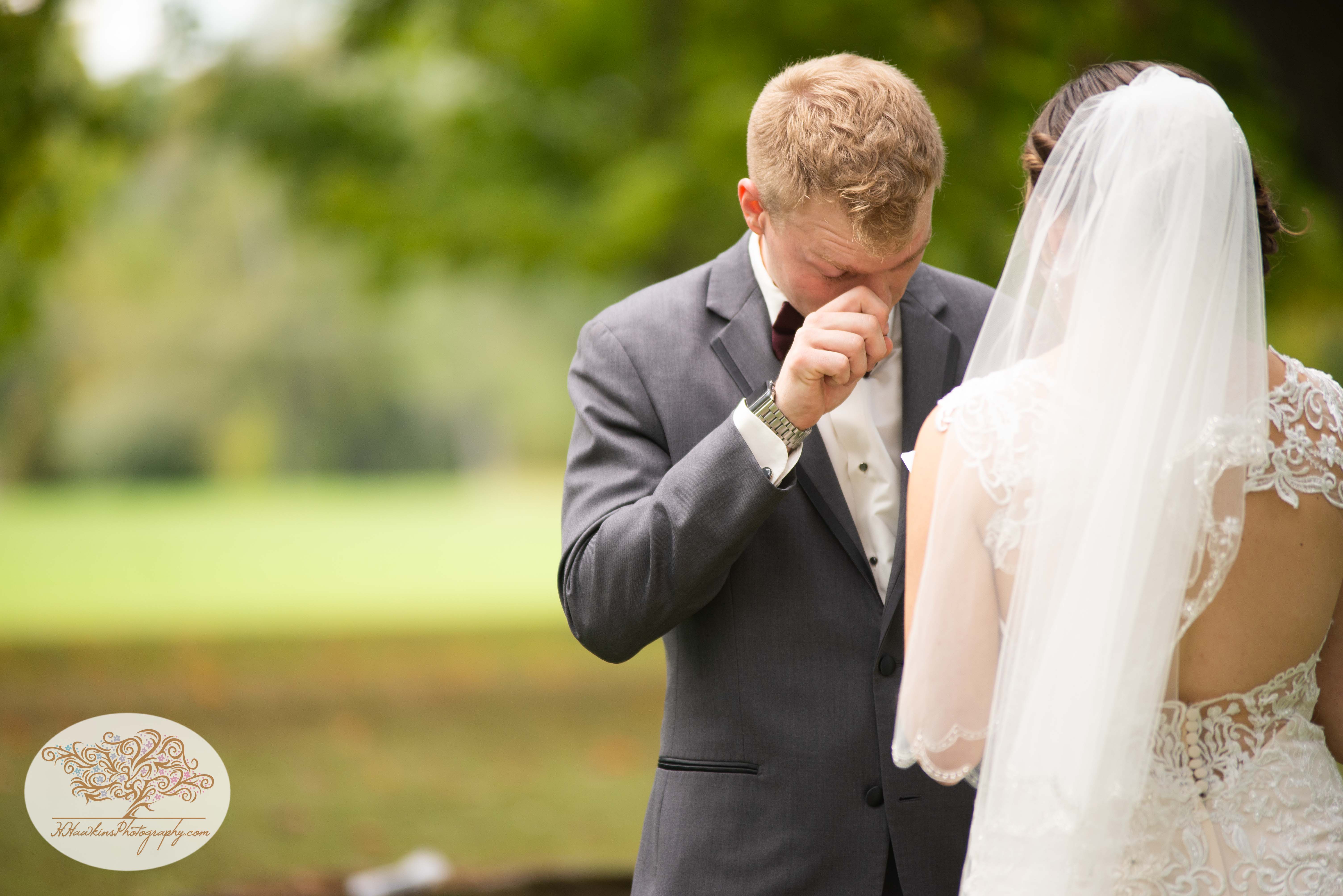 Groom wipes a tear from his eye during their first look