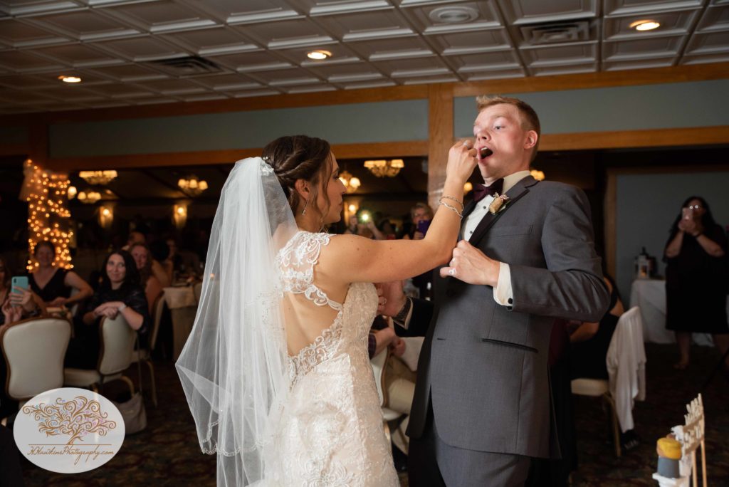 Bride teases groom as she feeds him wedding cake