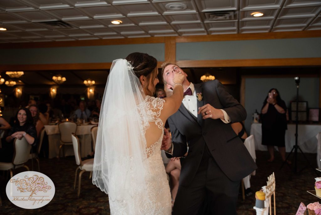 Bride tries to smush wedding cake on the groom's face