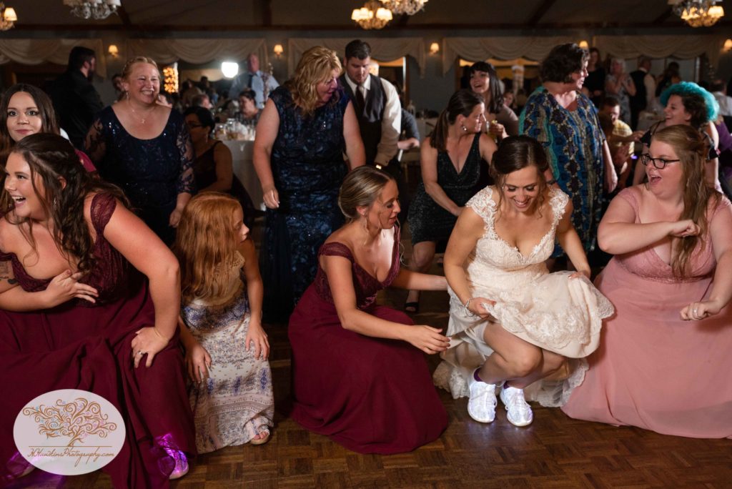 Bride and her bridesmaids get low on the dance floor at their Upstate NY castle wedding at Belhurst