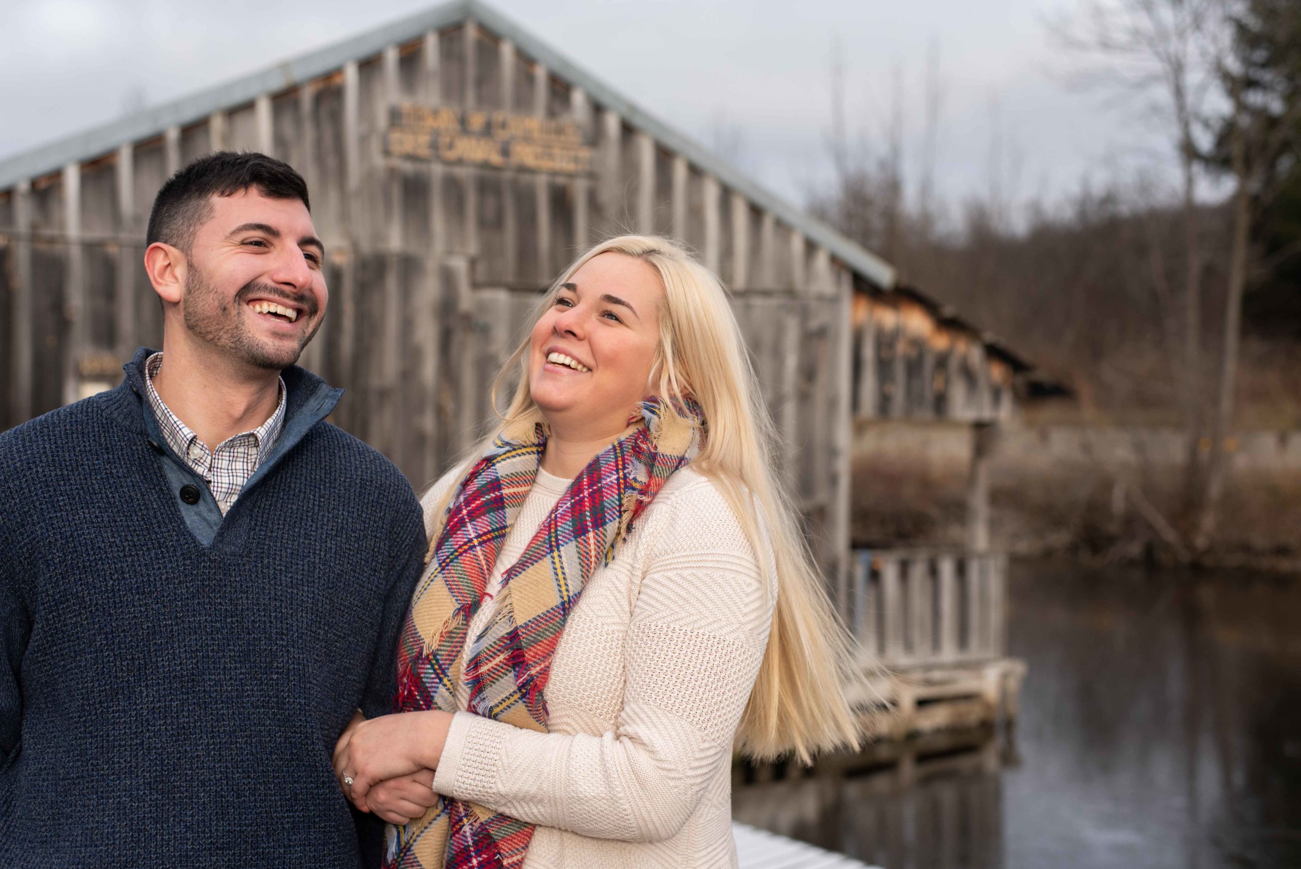 Bride and groom laugh together during their engagement photos session in Syracuse in the fall