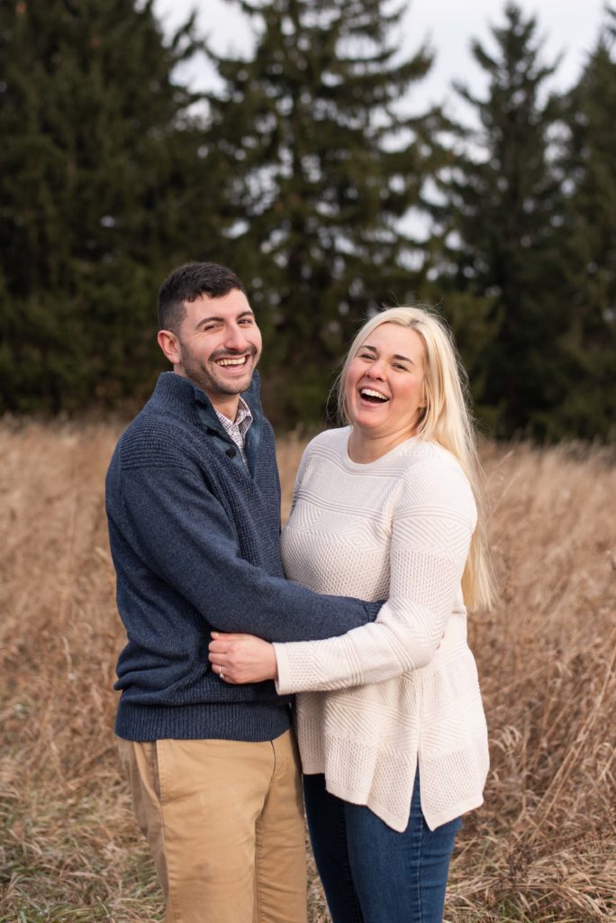 Bride and groom laugh together during their engagement session by Syracuse wedding photographer