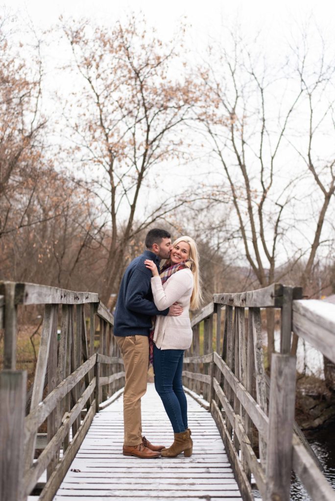 Bride and Groom to be stand on wooden bride over the Erie Canal in Syracuse during their fall engagement photo session