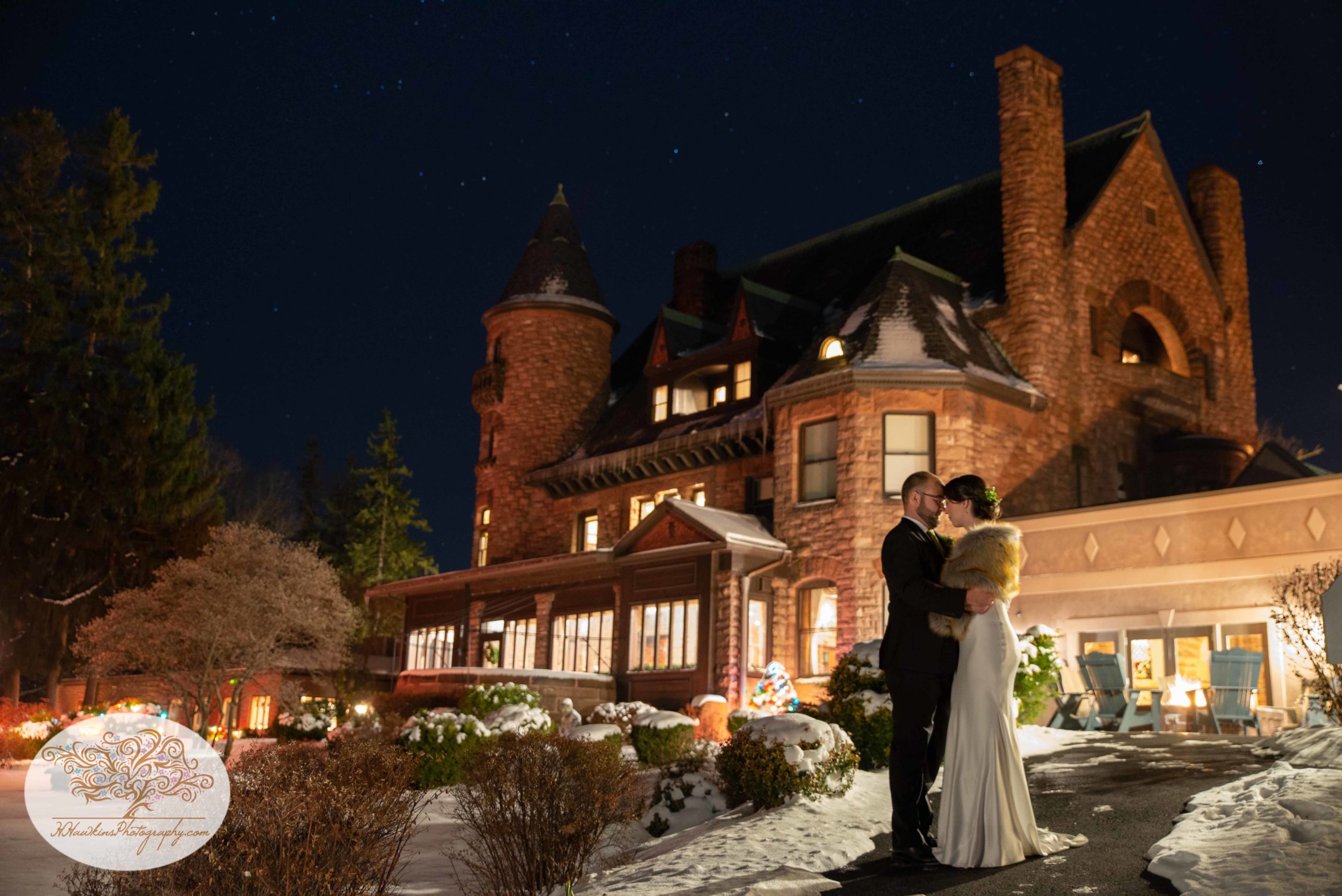 Belhurst Castle at night with bride and groom in front