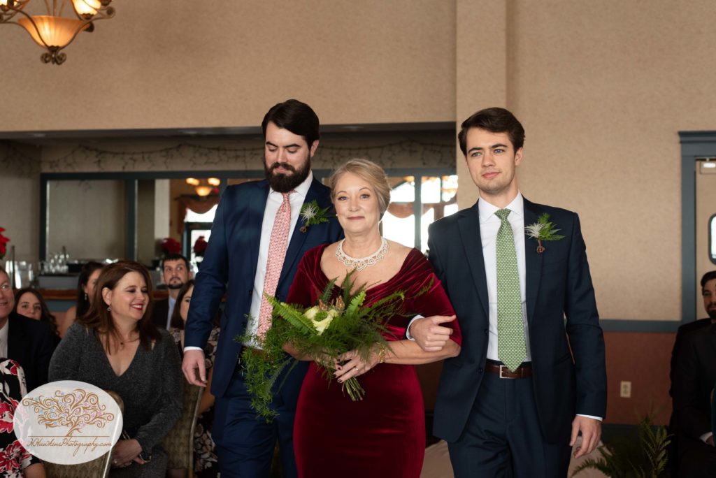 Mother of bride escorted by her two sons down the aisle