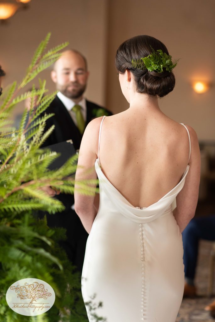 Back of the bride with greenery in her hair