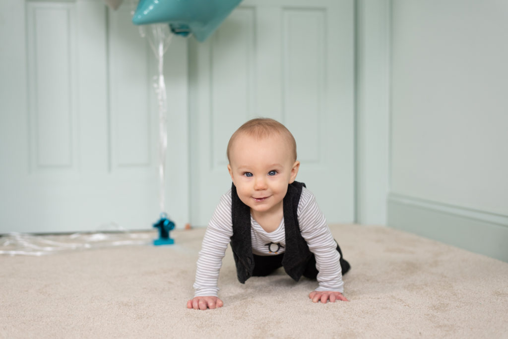 little boy crawls towards camera during 1 year old portrait session