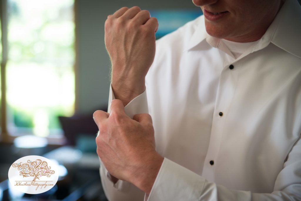 Groom puts his cuff links on before his wedding ceremony