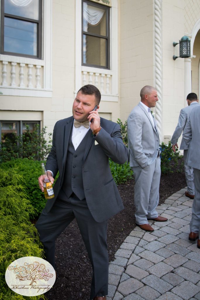 Groom talks on his phone during the morning of the wedding