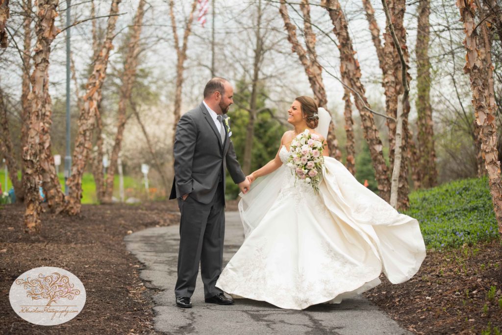 groom twirls bride in her wedding dress in a grove of white birch trees