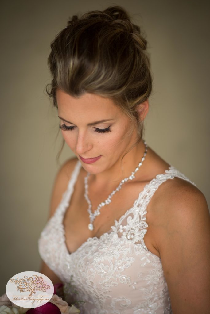 bride looks down showing off her beautiful eye lashes in her white lace wedding dress