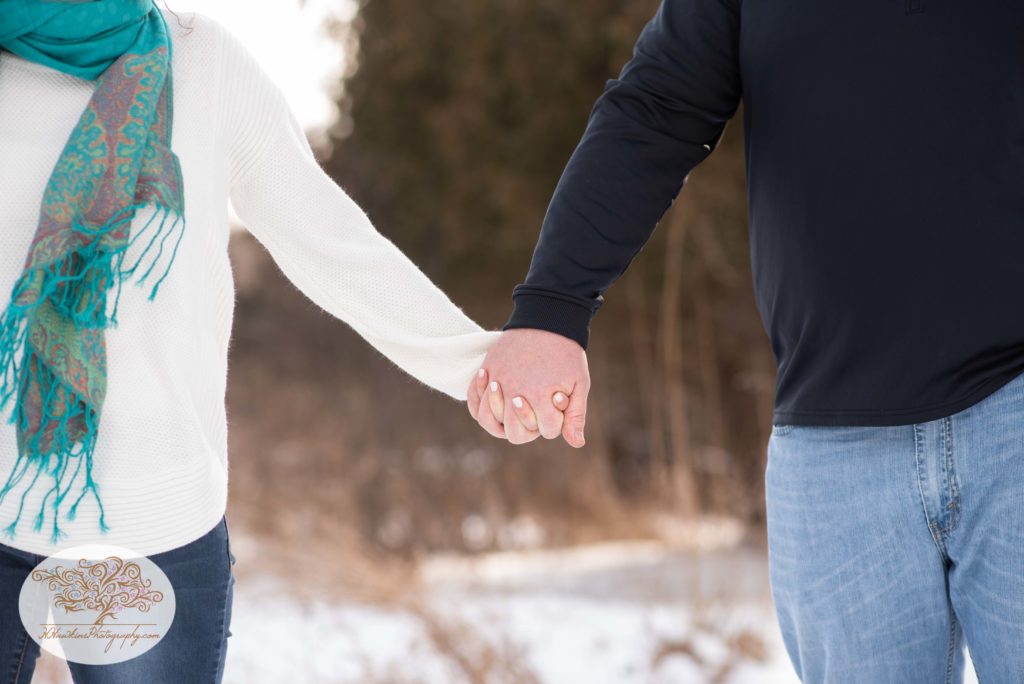 Close up photo of engaged couple holding hands