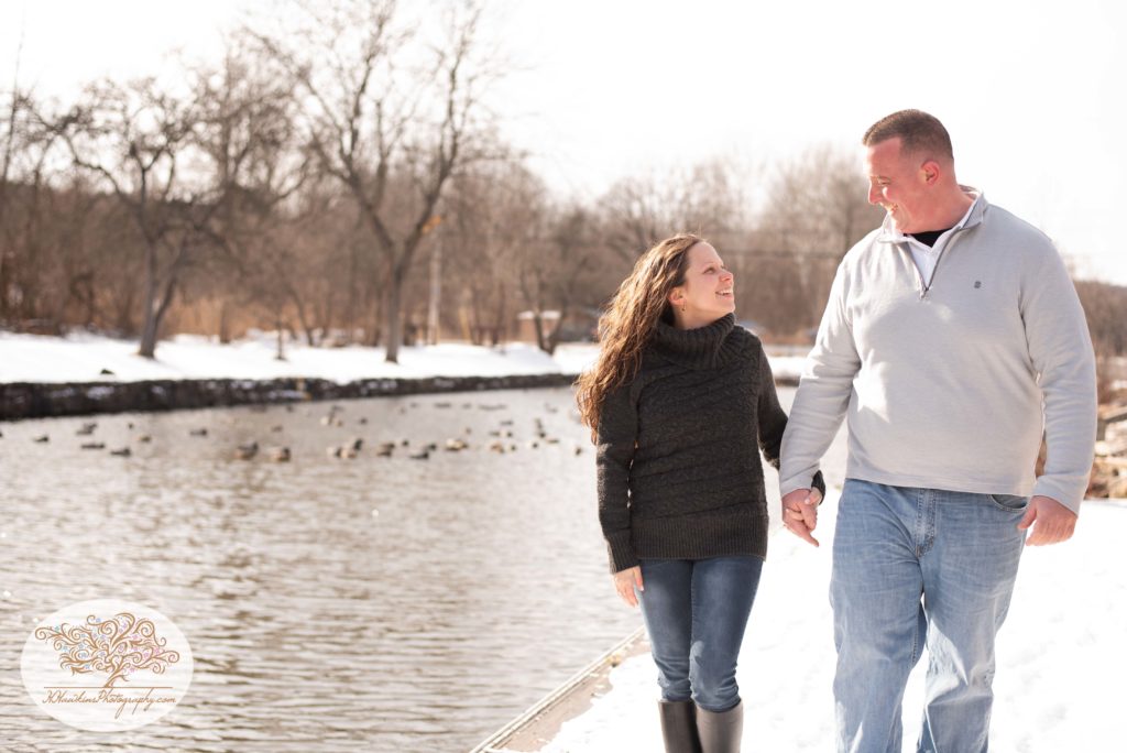 bride and groom to be walk along snowy dock at the Erie Canal in Camillus NY