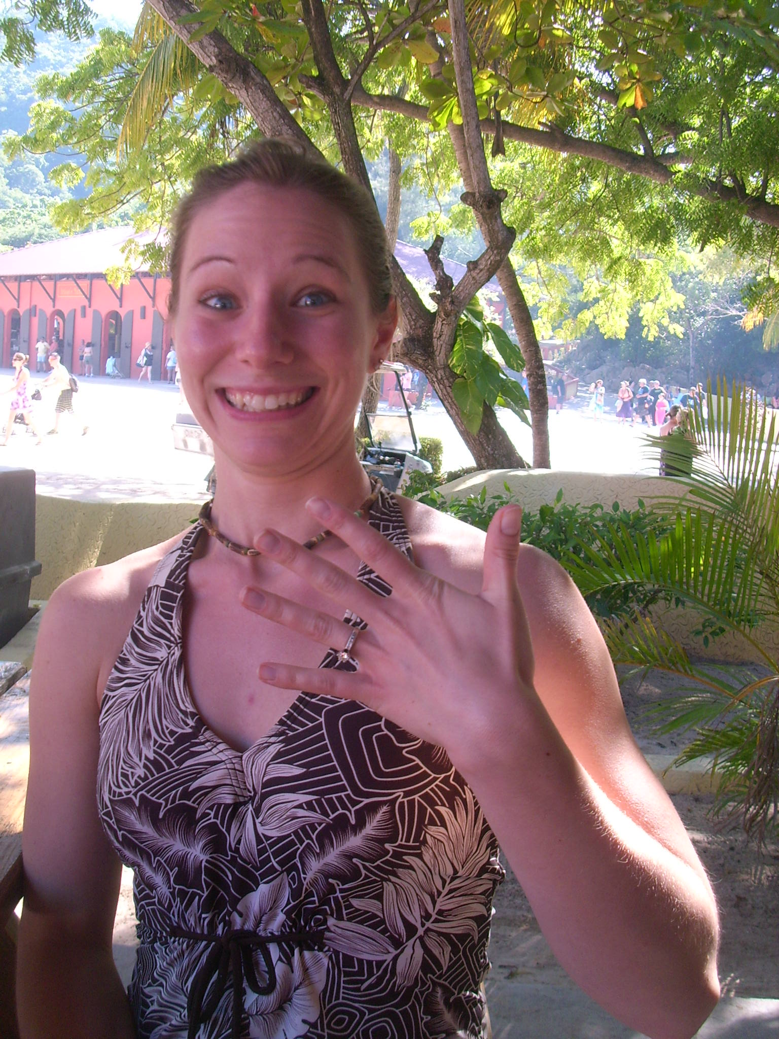 Girl excitedly holds up her diamond ring after getting engaged