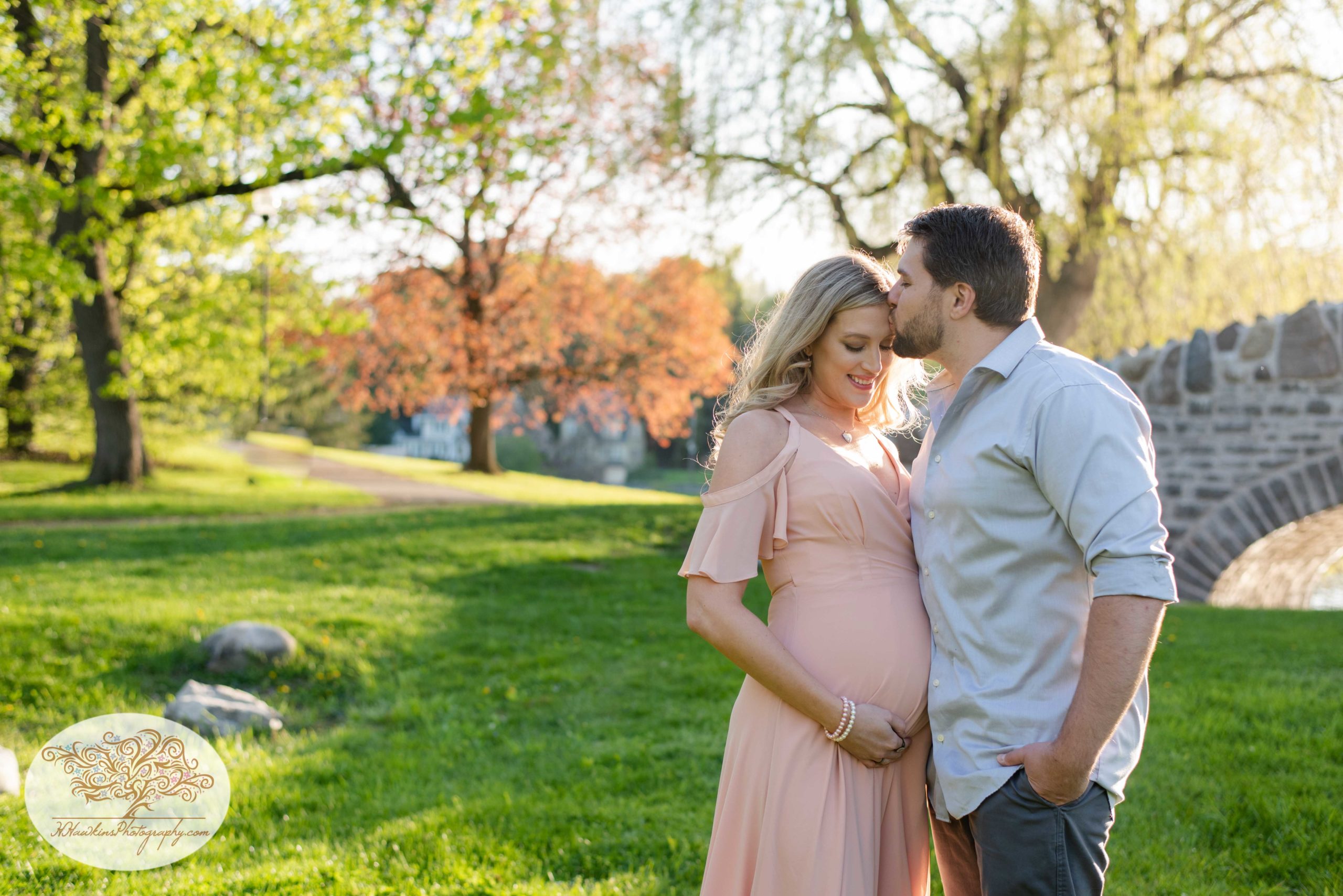 dad to be kisses mom to be on the forehead during their maternity pictures