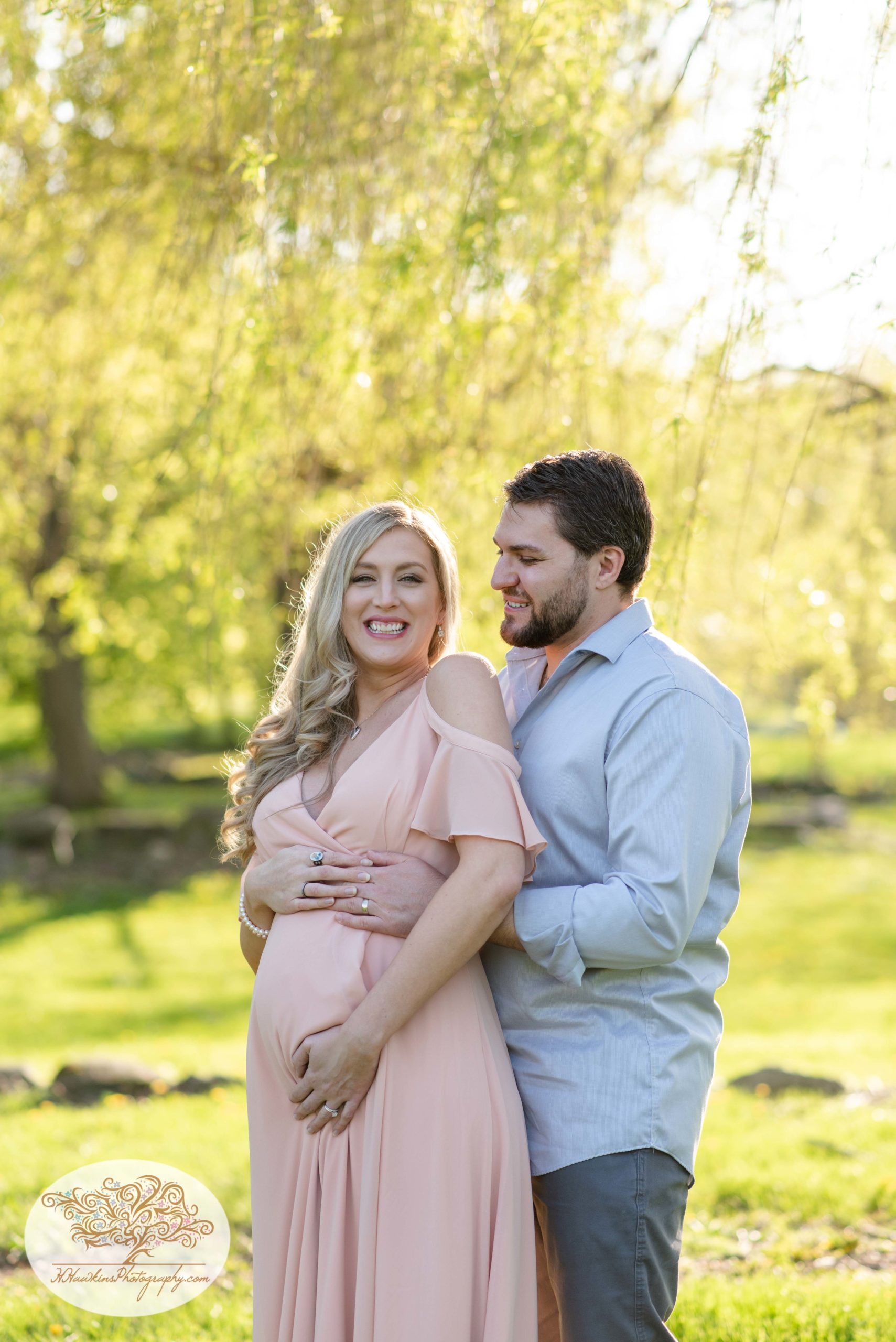 Expectant mom laughs at camera during her maternity session