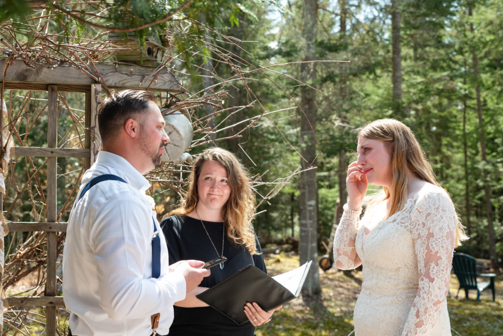 Bride wipes a tear from her eye during wedding ceremony in Lake Placid captured by Adirondack photographer