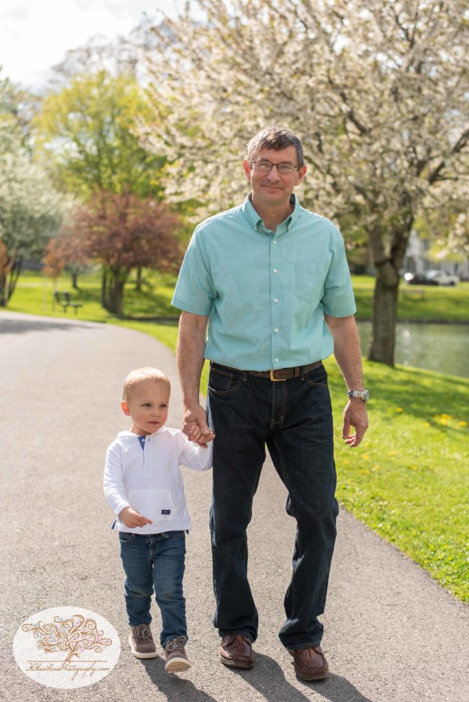 Grandpa and grandson walk hand in hand along a path at Hoopes Park Auburn NY