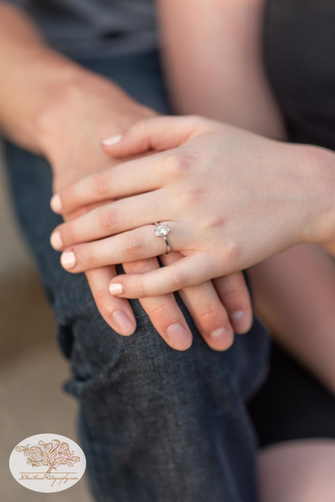 The hands of a newly engaged couple with her engagement diamond ring on her finger