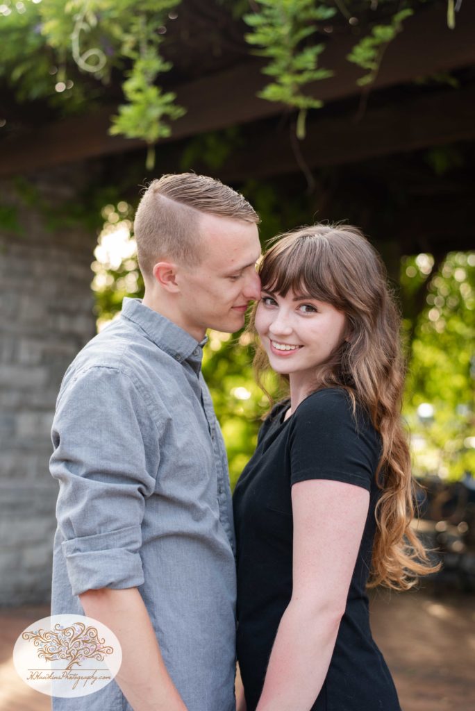 Groom to be kisses bride on her temple during their engagement pictures at Franklin Square Park in Syracuse, NY