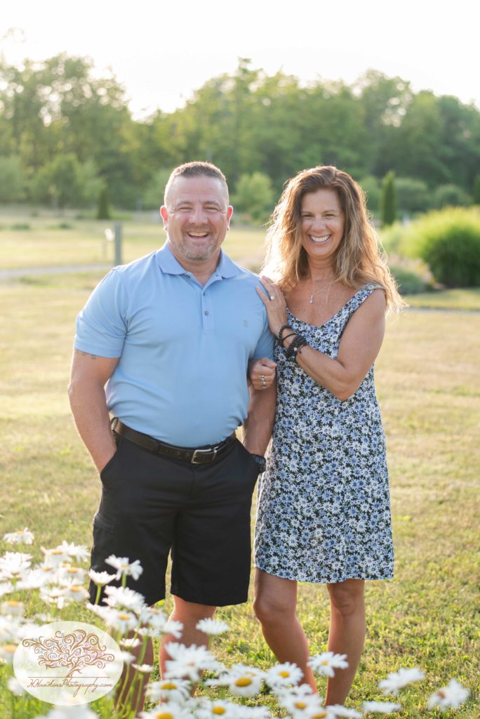 Bride and groom stand in a field with the sun behind their backs at Anyela's Vineyard in Skaneateles NY