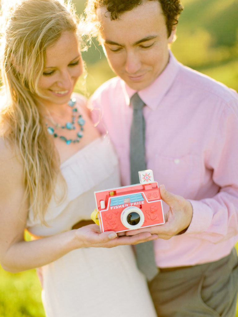 mom and dad hold fisher price camera for pregnancy announcement that ended in miscarriage