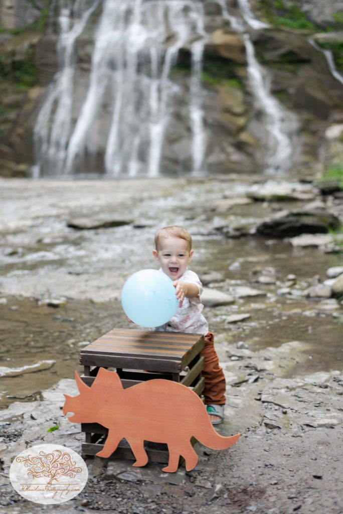 One year old in front of delphi falls holding a blue balloon