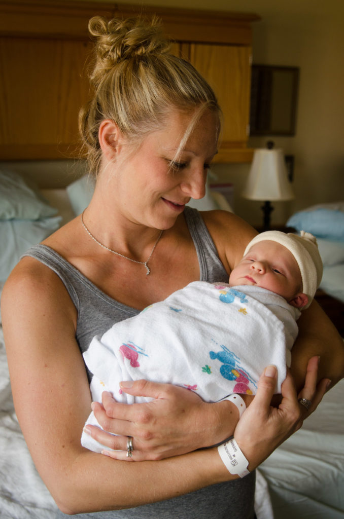H Hawkins Photography wedding photographer in Syracuse holds new baby boy in hospital