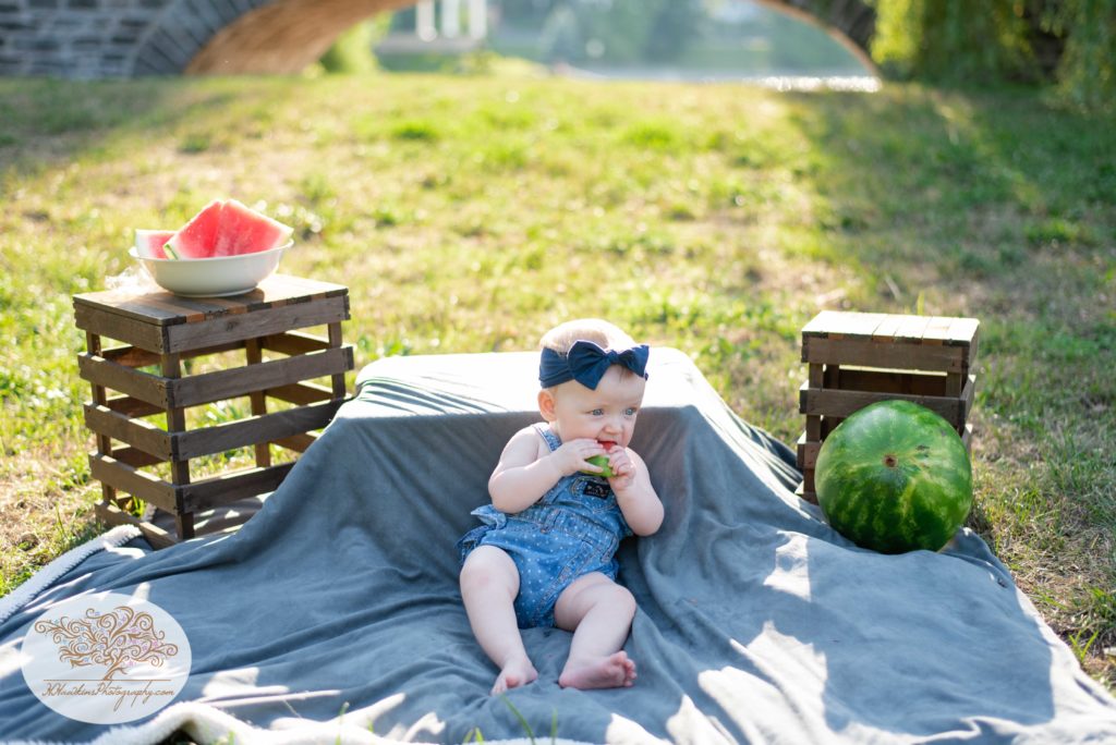 Little girl eats a summer watermelon while Syracuse family photographer takes pictures