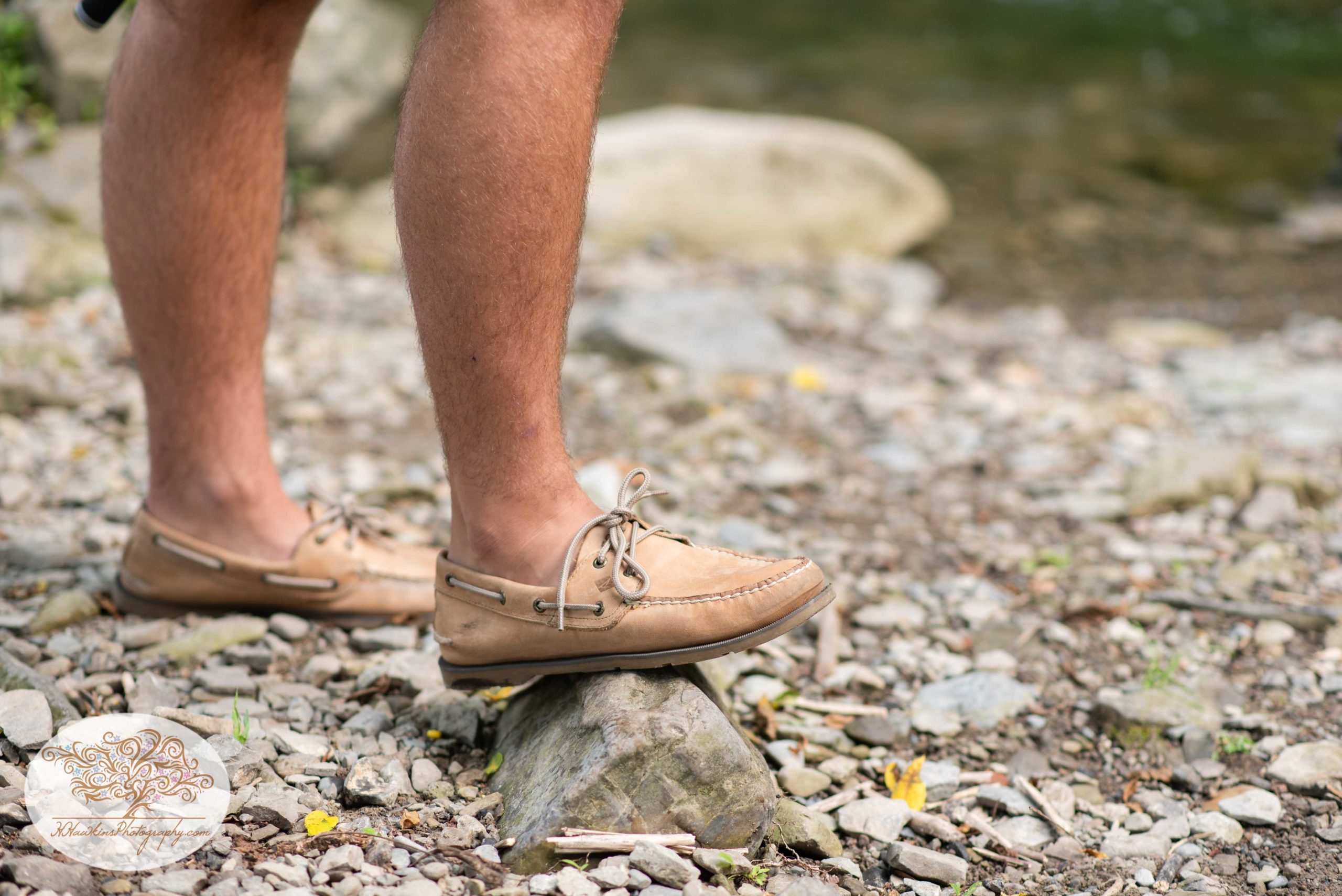 Syracuse high school senior pictures of a guy's shoes standing on a rock in front of Nine Mile Creek in Marcellus