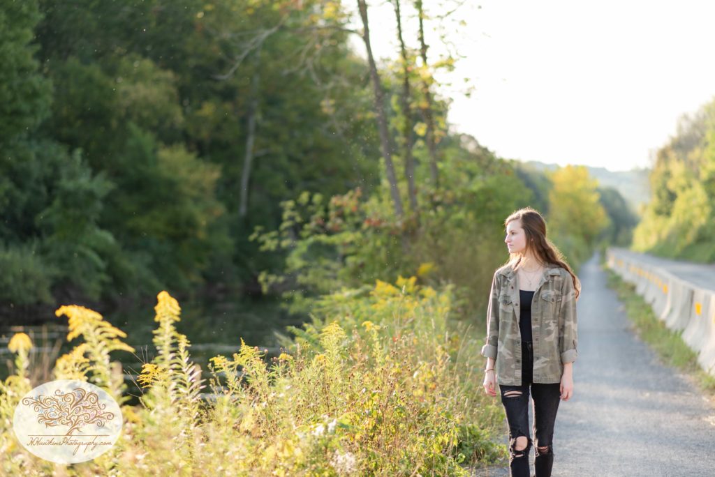 HIgh school senior girl for her senior pictures session walking along the Erie Canal in Camillus near the Camillus Sportsmen Club