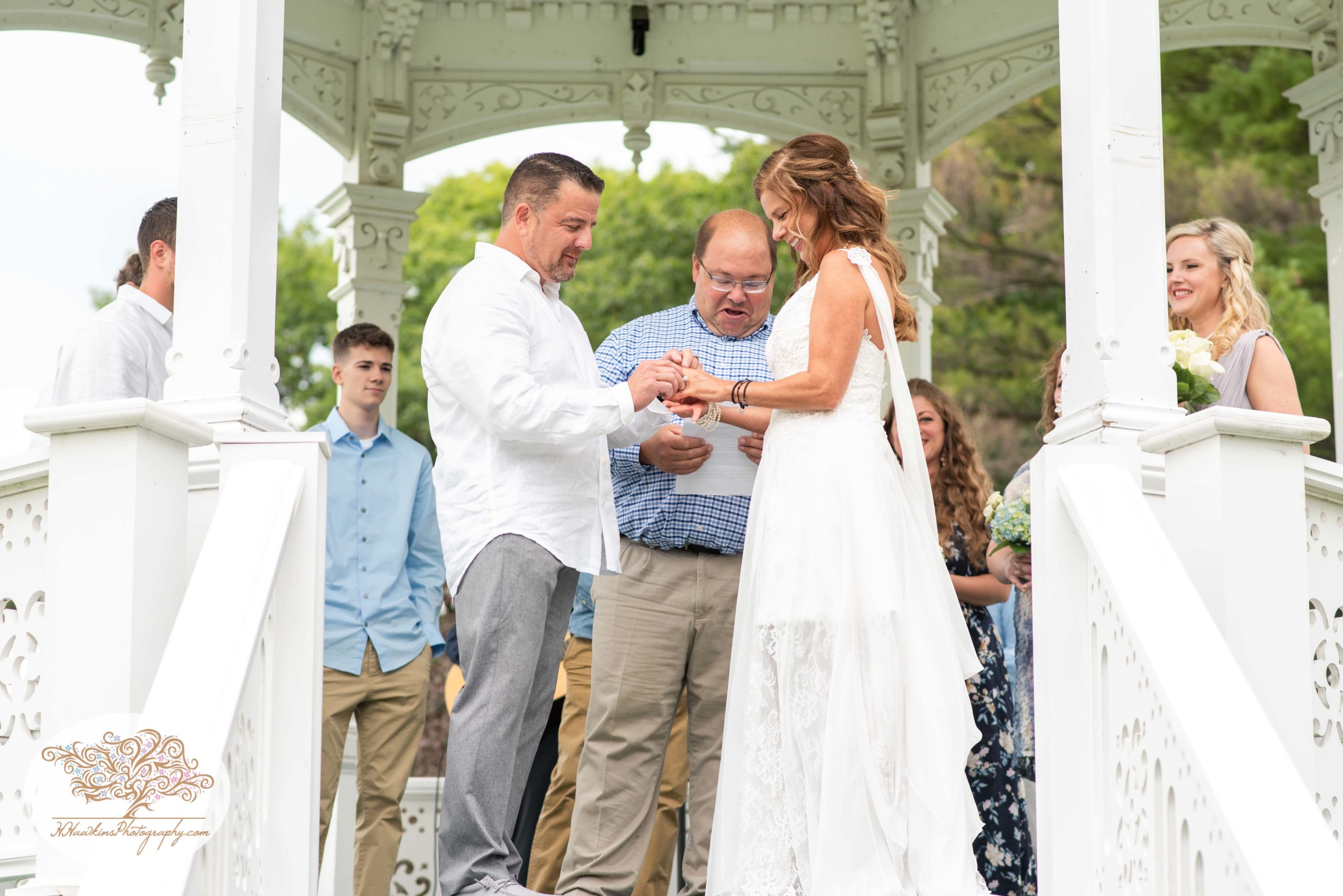 Bride and groom exchange rings in fingerlakes wedding ceremony at gazebo Bride's sons escort her down the aisle at Fingerlakes Wedding at Hoopes Park Auburn NY