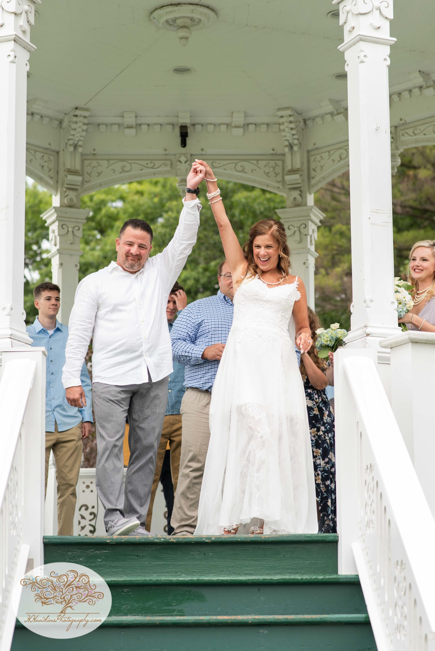 Bride and groom cheer in the gazebo at Hoopes Park in Auburn NY during the Fingerlakes Wedding by Syracuse photographer