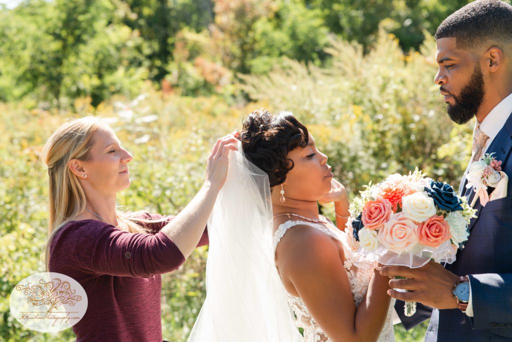 Syracuse wedding photographer puts the veil back into bride's hair after it falls out